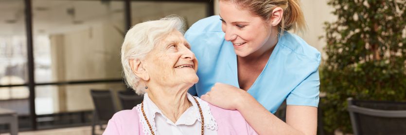 Une personne âgée et un proche aidant (image chaleureuse et réconfortante).